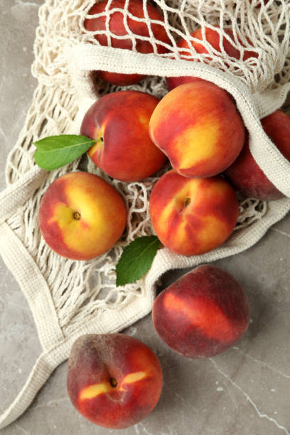 istock String bag with peach fruits on gray textured table 1481608608