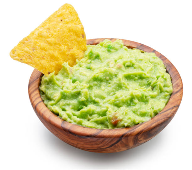 istock Guacamole bowl and corn chips dipped in it on white background. Top view. File contains clipping path. 1481609995
