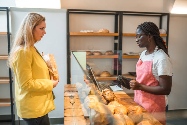 istock Caucasian Female Selecting Fresh Bread At An Artisan Bakery 1481610990