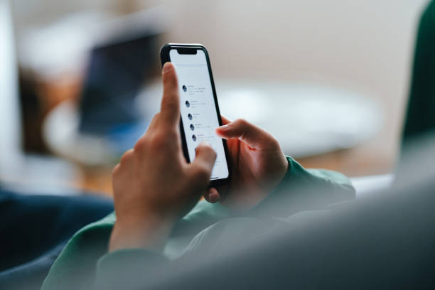 Close Up Photo Of Teenager Hands Using A Mobile Phone At Home Unrecognizable teenage boy typing text messages on his smartphone while lying on a couch at home. whatsapp screen stock pictures, royalty-free photos & images