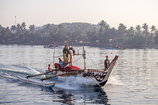 Mirissa - Galle, Sri Lanka - February 12th 2023: Classic outrigger fishing boat in the harbor in Mirissa which is the harbor for the old city Galle in the south of Sri Lanka