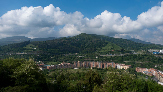 Bilbao suburb with clouds and mountain in background with blue sky