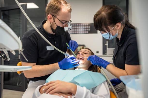 인간 치과 의사는 치과 진료소에서 웃는 어린 소녀를 수술하고 있습니다. - dentist dental assistant dentist office dental drill 뉴스 사진 이미지