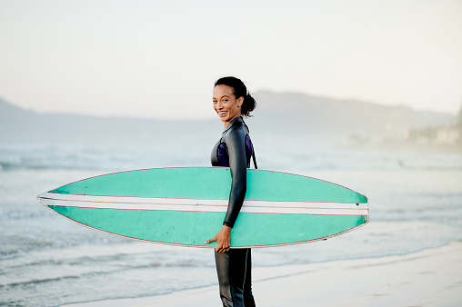 Portrait, surfboard or happy woman at sea for fitness training, workout or sports exercise on Hawaii beach. Smile, surfer or mixed race girl smiling on fun summer holiday vacation ready for surfing