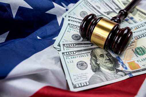 the gavel is placed together with dollars on the background of the flag of the United States of America. symbol of jurisdiction. Bribes in the justice system of the country