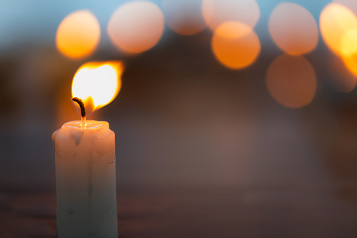Candles lit in a church with blurred background
