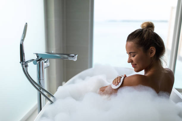 istock Rear view of smiling woman taking a bath. 1481626690