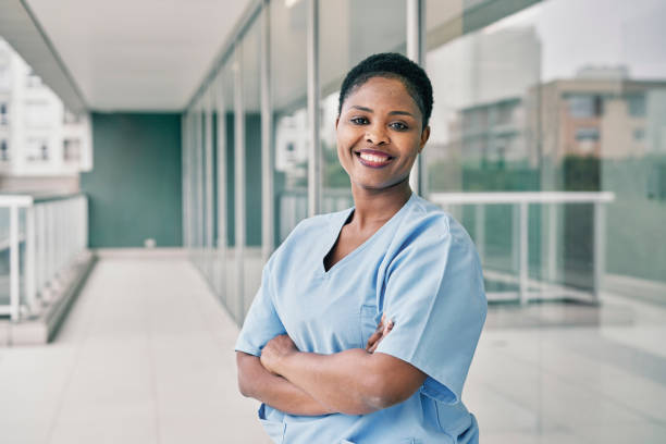 Portrait of a cheerful young african woman nurse working in hospital stock photo