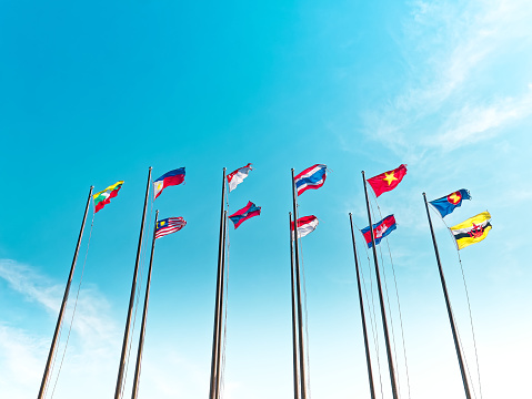 Low Angle View of Waving Flags of ASEAN Countries Against Blue Sky
