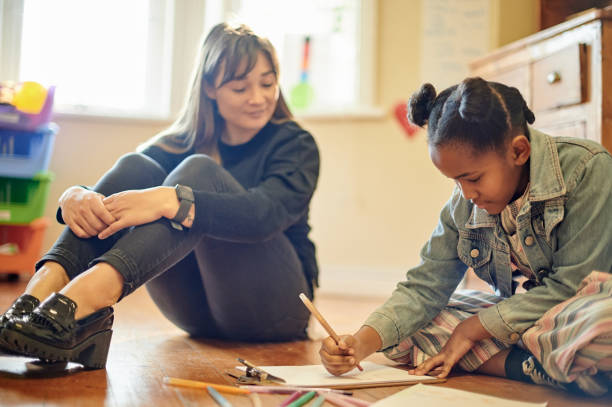 Creative, teacher and girl drawing for education, art therapy and expression in a classroom. Support, project and a woman with a student for learning creativity and helping with writing homework