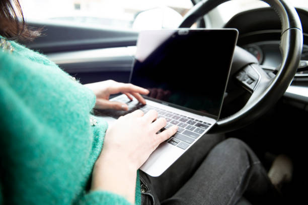 istock Woman browsing laptop in car 1481630122