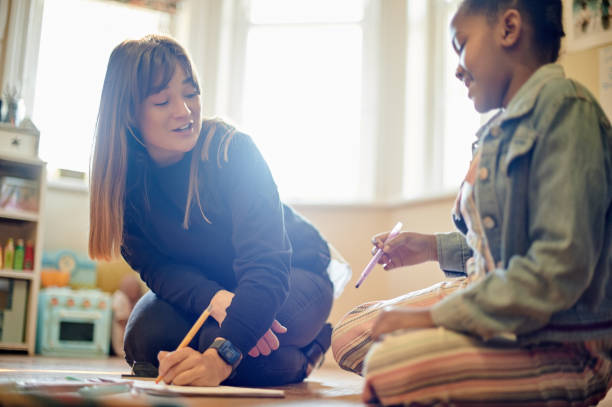istock Homework help, kid and drawing in a house learning and writing for education. Knowledge development, home schooling and girl coloring for creativity study and student with woman support and care 1481630383