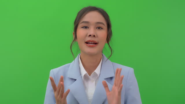 Young asian woman talking to camera with green screen background.