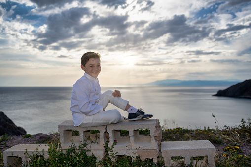 Unwavering confidence: A stylish boy on a sunset cliff. Breathtaking scenery and striking model. Beauty and composure blend in this awe-inspiring moment, uplifts the spirit.