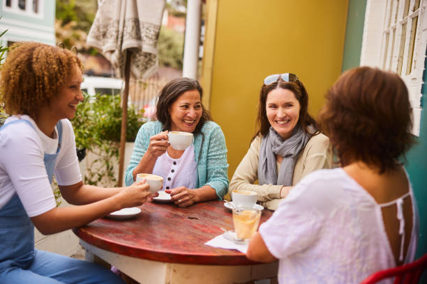 istock Smiling mature women talking over coffee at a sidewalk cafe 1481634004