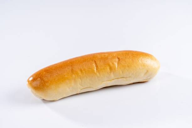 istock Freshly-baked hot dog bun sits on a white surface 1481635759