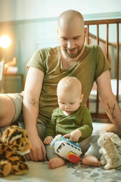 istock Learning, playing and development, happy man and baby on nursery floor, new dad and infant bonding with toys in playroom. Family, love and young father with child in bedroom with toy at home together 1481637783