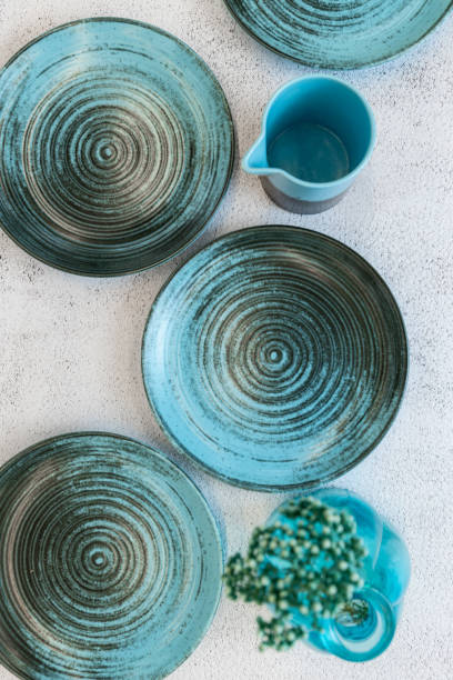 istock Ceramic set of blue empty kitchen plates on a white marble background. Eco and minimal tableware. 1481640475