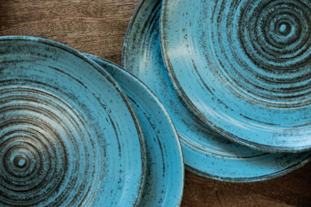 istock Ceramic set of blue empty kitchen plates on a white marble background. Eco and minimal tableware. 1481640476