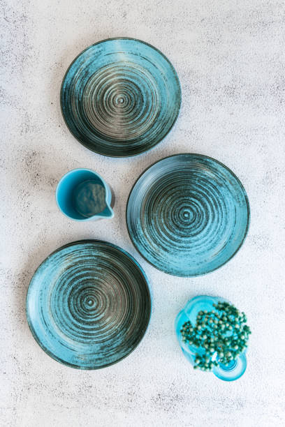 istock Ceramic set of blue empty kitchen plates on a white marble background. Eco and minimal tableware. 1481640478