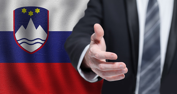 Slovenian business, politics, cooperation and travel concept. Hand on flag of Slovenia background.