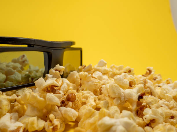 istock Popcorn and 3D glasses on a yellow background. Sweet popcorn on yellow. 1481642552