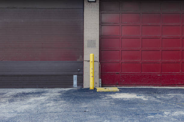 istock Two large red industrial garage doors and tired pavement 1481642963