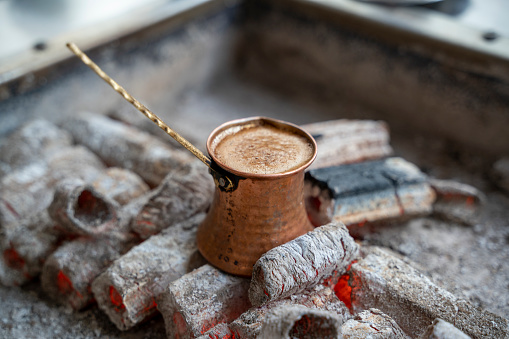 Turkish coffee tastes better when cooked slowly. that's why it's slowly cooking on embers.