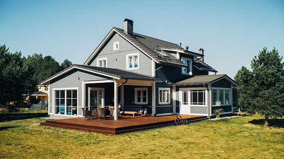 Casa de campo de estilo americano en un llamativo día de verano con cielo azul. Preciosa vivienda en zona residencial. Propiedad inmobiliaria. photo