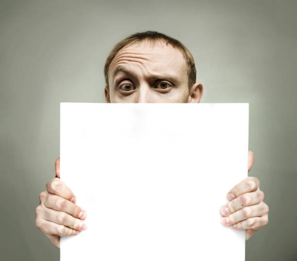 istock Young man holding blank sign paper 1481645516
