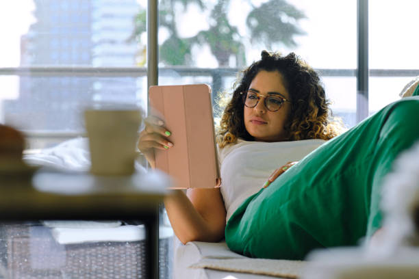 istock lateral view shot of a modern Peruvian woman stretched out on the sofa using a digital tablet on her apartment 1481645722