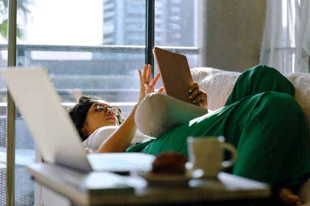istock lateral view shot of a modern Peruvian woman using a digital tablet on a couch at home 1481645737