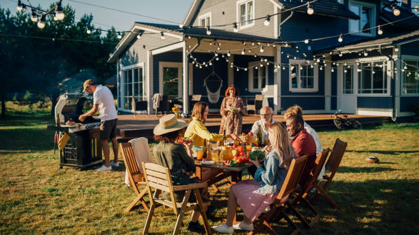 istock Group of Multiethnic Diverse People Having Fun, Communicating with Each Other and Eating at Outdoors Dinner. Family and Friends Gathered Outside Their Home on Warm Summer Day. 1481647276