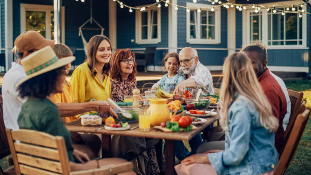 istock Group of Multiethnic Diverse People Having Fun, Communicating with Each Other and Eating Vegetarian Meals at an Outdoors Dinner. Relatives and Friends Gathered Outside Their Home on Warm Summer Day. 1481647409