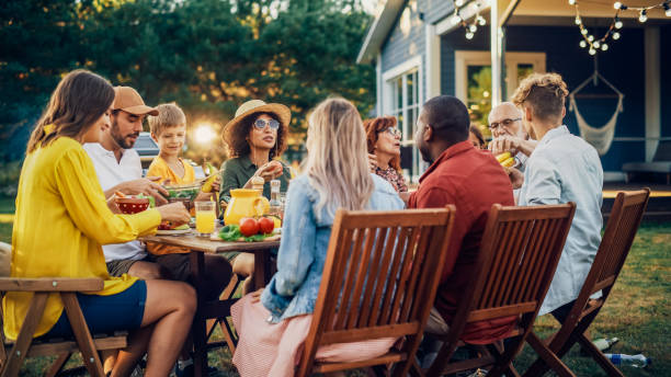 istock Group of Multiethnic Diverse People Having Fun, Communicating with Each Other and Eating Vegetarian Meals at an Outdoors Dinner. Relatives and Friends Gathered Outside Their Home on Warm Summer Day. 1481647455