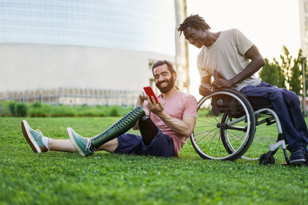 istock Multiracial friends with disability having fun using mobile phone at park city - Focus on man hand holding smartphone 1481649993