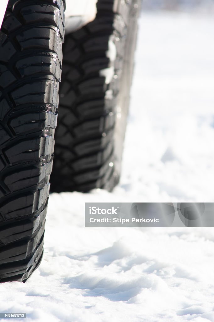 Tires of an white colored all-terrain vehicle in the snow 4x4 Stock Photo