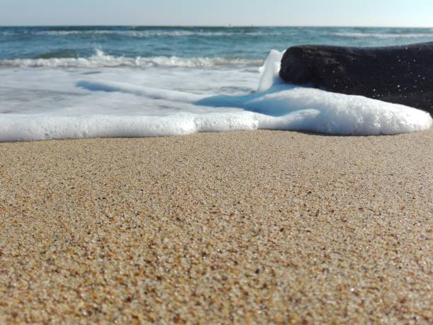 istock Close-up of waves splashing on the sandy beach 1481656339
