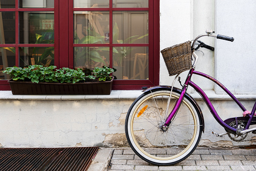 Purple vintage bicycle parked near old house in little European town