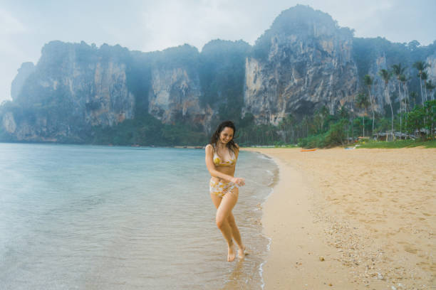 istock Cheerful woman running on the beach  under the rain 1481656764