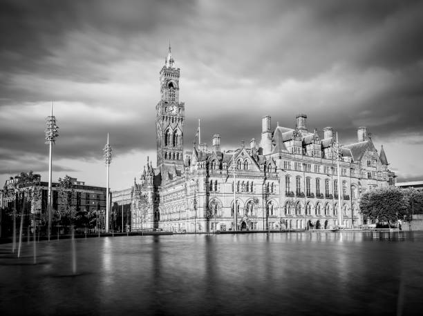 Dramatic shot of Bradford City Hall reflected in the mirror pool in the city park.