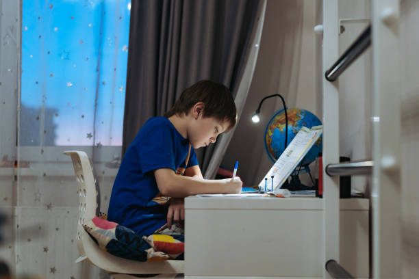 istock caucasian boy doing homework at home at the desk by the window. 1481662690