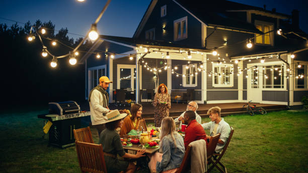 istock Group of Multiethnic Diverse People Having Fun, Communicating with Each Other and Eating at Outdoors Dinner. Family and Friends Gathered Outside Their Home on a Warm Summer Evening. 1481663175