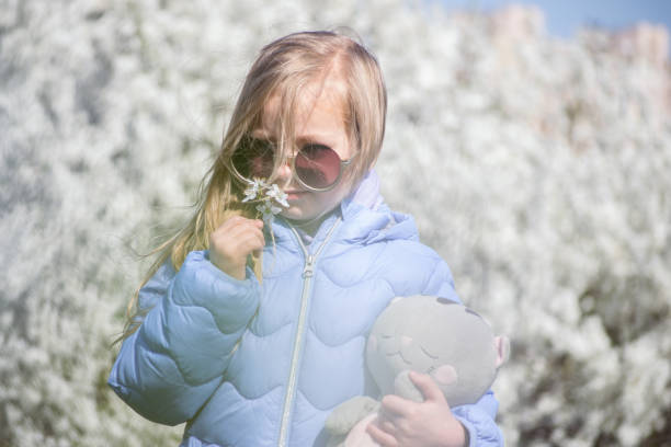 little girl on the background of a blooming tree in spring