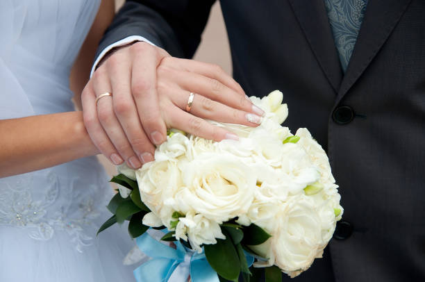 istock Hands with rings on wedding bouquet. Bride and groom 1481673242