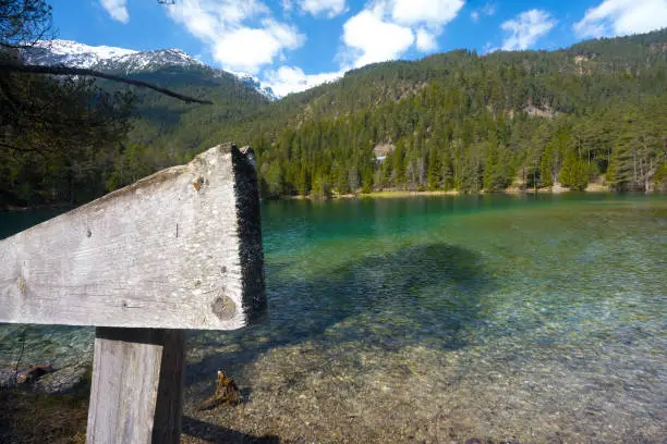 Photo of clear mountain lake Tyrol green water fence