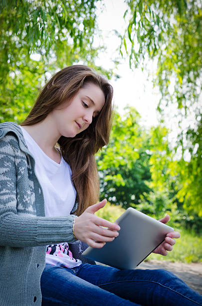 istock Girl working on a tablet in the green park summer 148167704