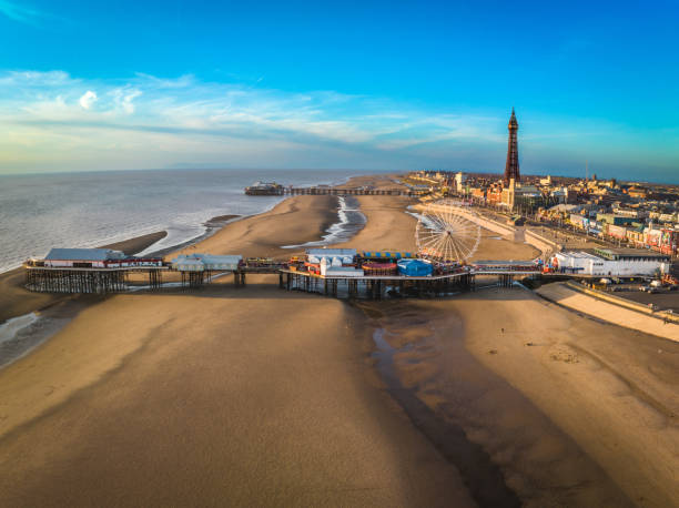 Blue Skies and Blackpool Beach An aerial photograph of Blackpool Beach and Tower. The photograph shows North and Central Piers and the famous Blackpool Tower. The photograph was produced on a gloriously sunny day with blue skies which enhanced the golden no colour of the sandy beach. Blackpool Tower stock pictures, royalty-free photos & images