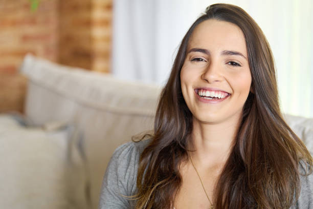 istock Young woman laughing while sitting on her living room sofa 1481684156
