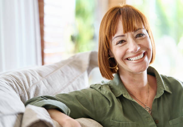 istock Woman smiling while relaxing on her sofa at home 1481684189
